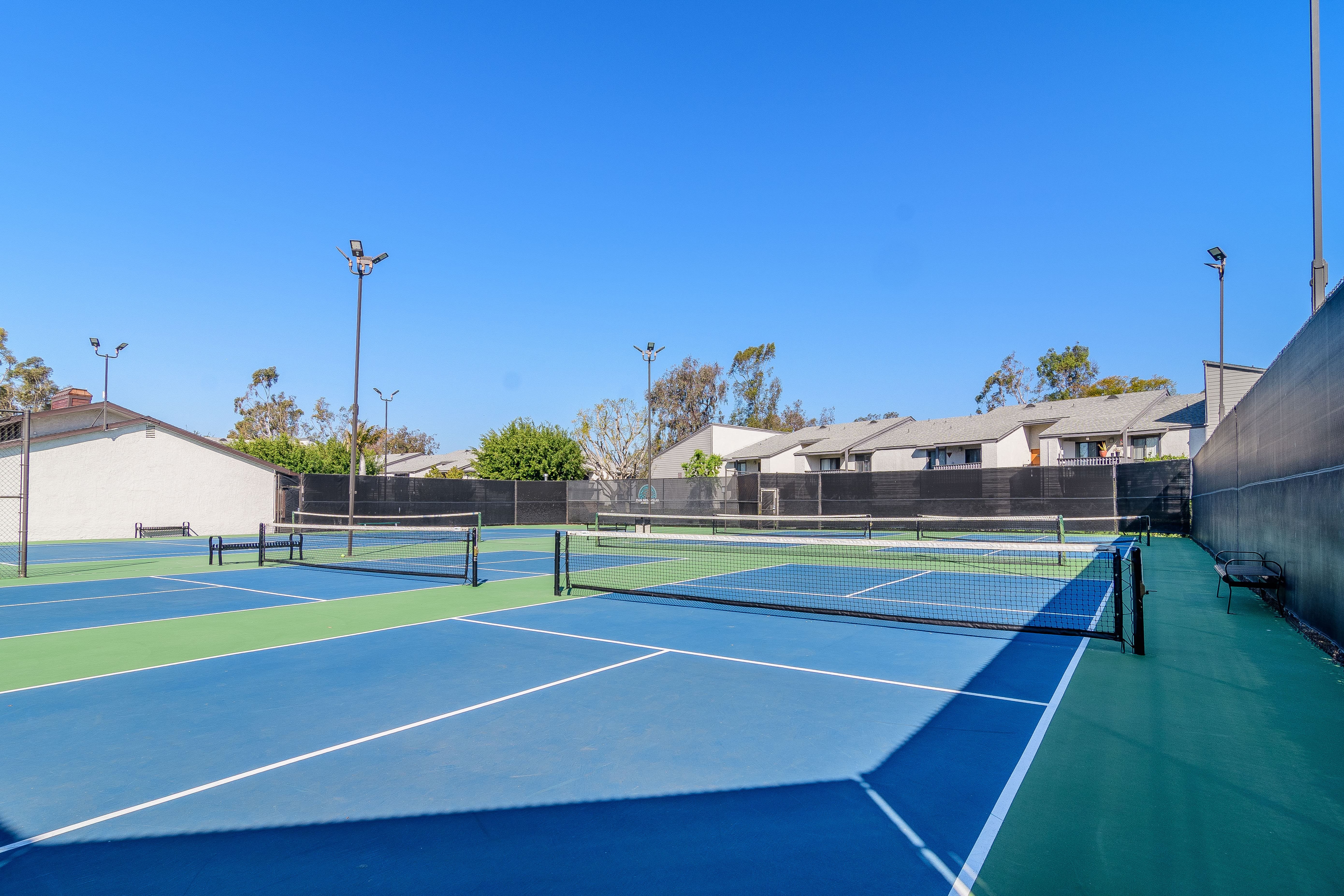 A tennis court with a blue surface and white lines.